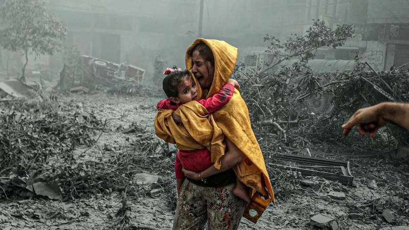 Fotografia dimineții - O femeie își ține în brațe fetița după un bombardament în Fâșia Gaza
